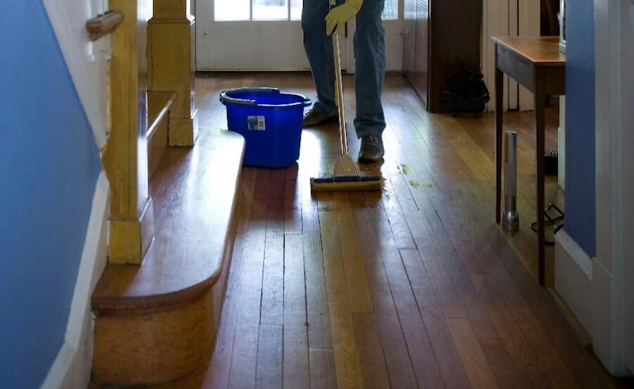 A man cleaning the floor of his apartment.