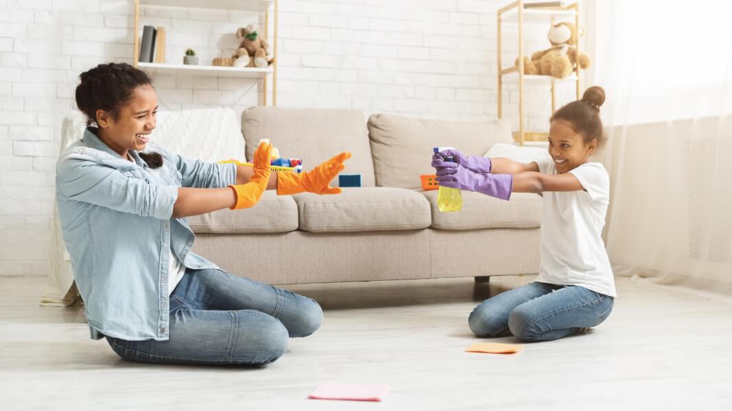 Playful girls having fun during cleaning home
