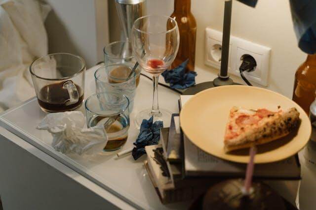 Messy nightstand with leftover food, drinks, and trash. Avoid pest issues while your home is on the market.